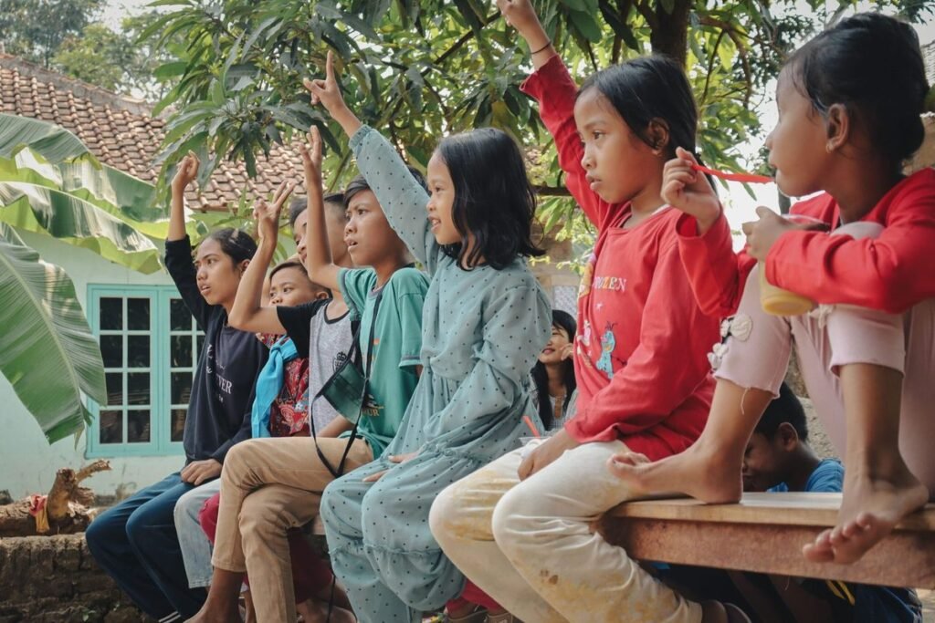 Children raising their hands, representing the idea of speaking up and asking questions.