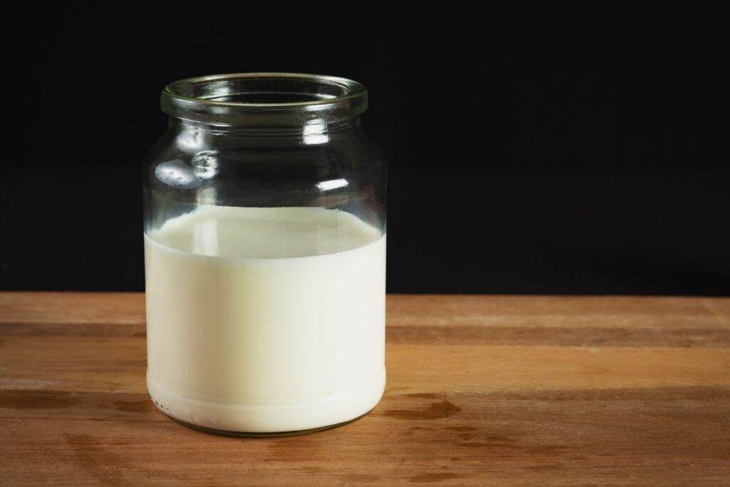 A jar of fresh pumped breast milk, representing the stash pumping helps build.